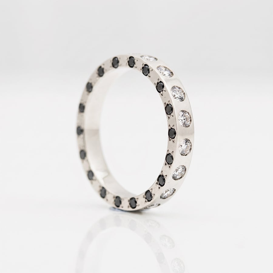 Unique eternity ring black and white natural diamonds flush set on three sides