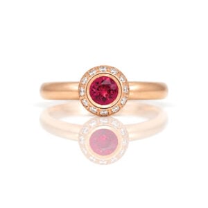 Burmese ruby rub-over set framed with diamonds in 18ct rose gold ring