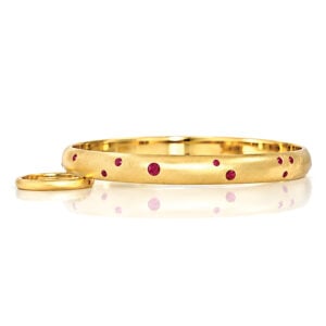 Solid 18ct yellow gold bngle with flush set natural rubies