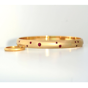 Rubies flush set in 18ct yellow gold bangle