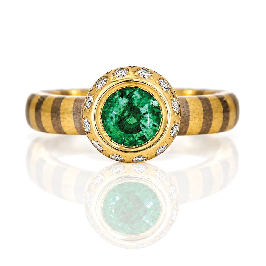 Round emerald set in gold with diamonds, on a gold striped ring David Ashton 1007. Modern fine jewellery