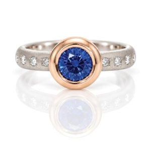 Vibrant blue Sapphire rub-over set in rose gold on a diamond set platinum ring David Ashton 1022