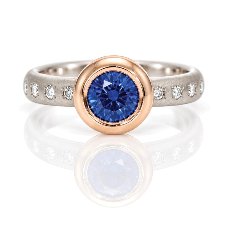 Vibrant blue Sapphire rub-over set in rose gold on a diamond set platinum ring David Ashton 1022
