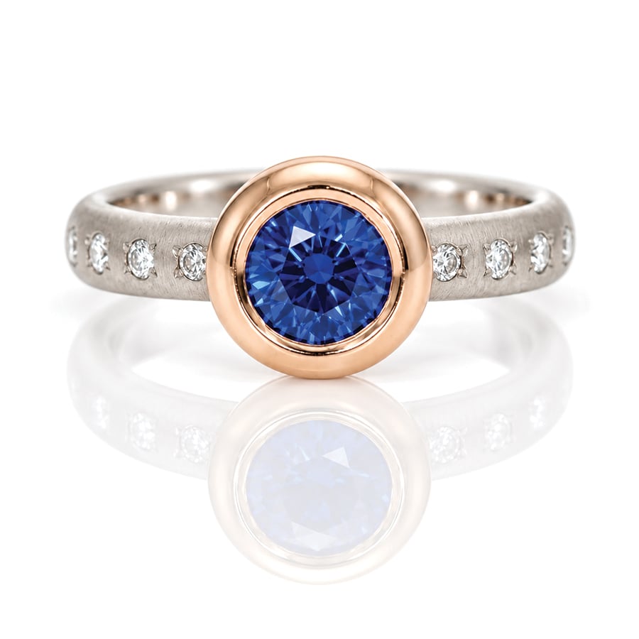 Vibrant blue Sapphire rub-over set in rose gold on a diamond set platinum ring David Ashton 1022