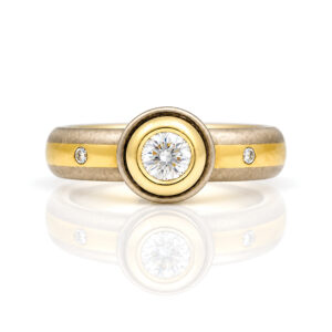 Diamond rub-over set in yellow gold on center stripe ring