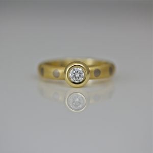 Brilliant cut diamond rub-over set 18ct gold ring with dots