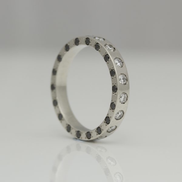 Platinum ring set with black & white diamonds on three edges