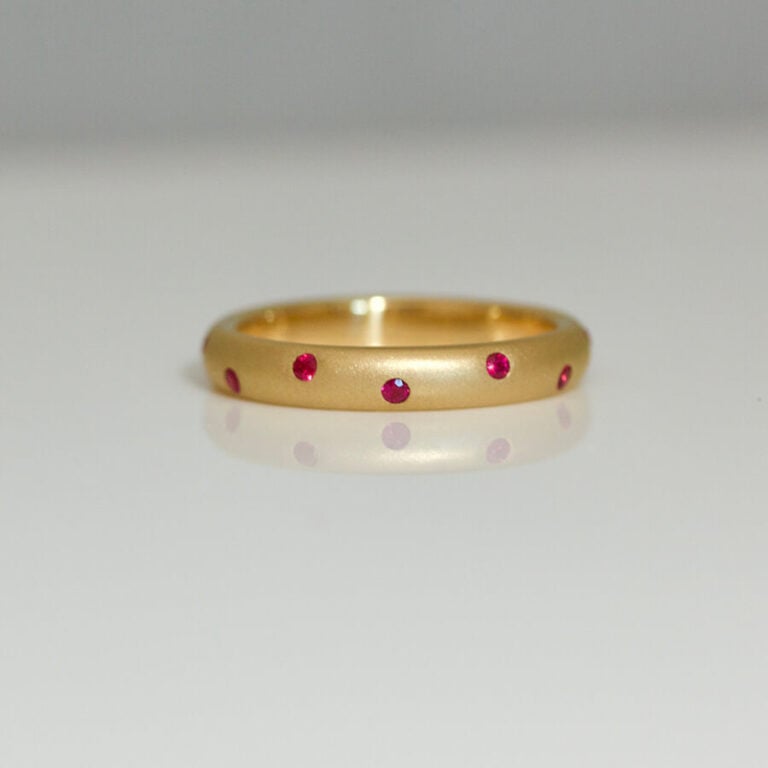 Vibrant red rubies randomly flush set in 18ct yellow gold ring