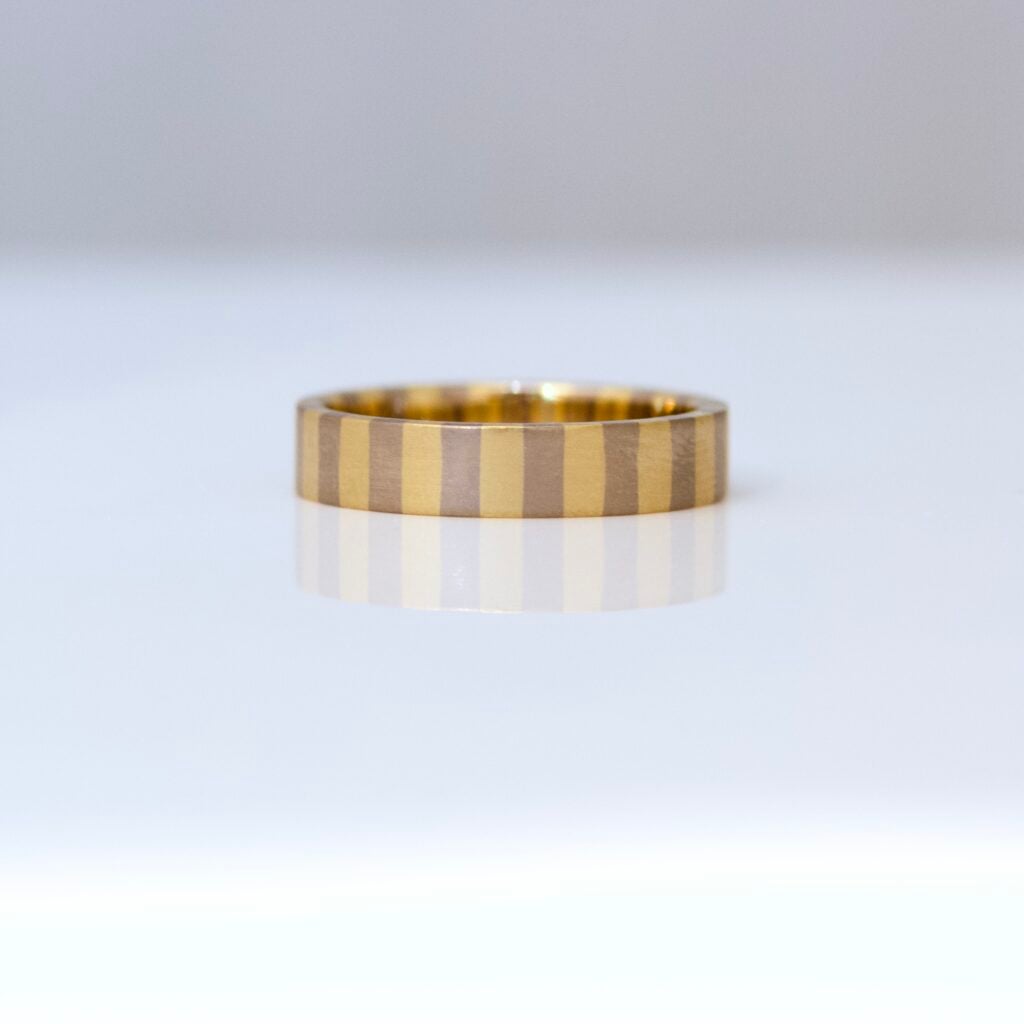 A flat profile ring with yellow and white stripes