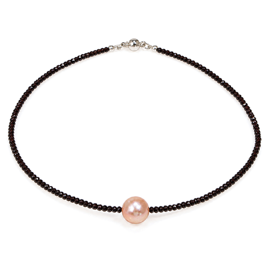 A pinky peach natural colour pearl in the middle of a string of faceted black spinel. bespoke fine modern jewellery handmade in London