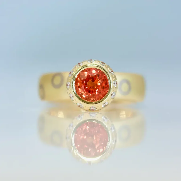 Round orange sapphire set in god with diamonds ring mokuma gone. bespoke fine modern jewellery UK