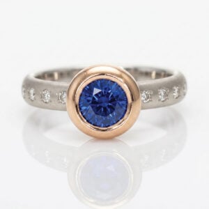 Vibrant blue Sapphire rub-over set in rose gold on a diamond set platinum ring David Ashton 1022a modern fine jewellery hand made in London