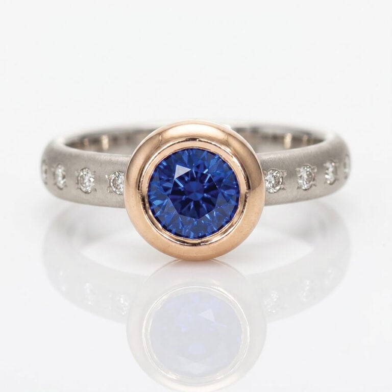 Vibrant blue Sapphire rub-over set in rose gold on a diamond set platinum ring David Ashton 1022a modern fine jewellery hand made in London