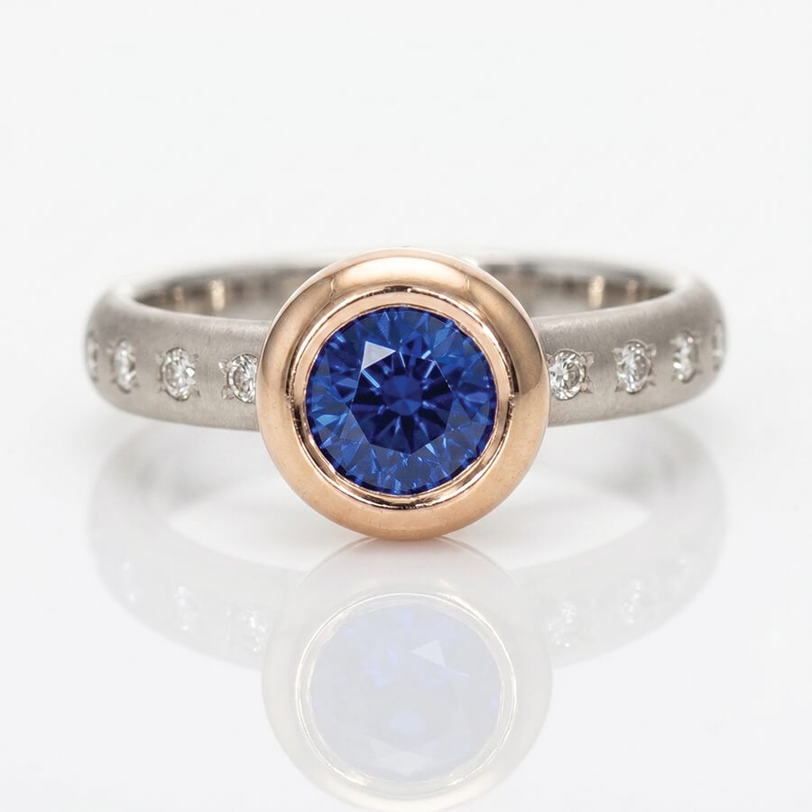 Vibrant blue Sapphire rub-over set in rose gold on a diamond set platinum ring David Ashton 1022a modern fine jewellery hand made in London